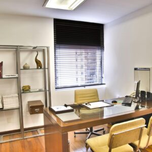 Sleek and contemporary office space featuring a wooden desk, chairs, and organized shelves.